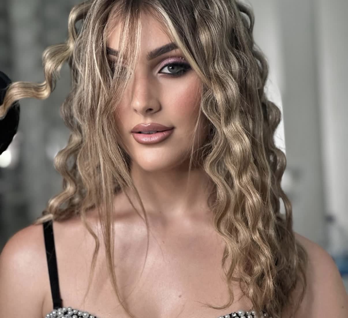 Primer plano de Lourdes con el pelo ondulado y maquillaje de sesión